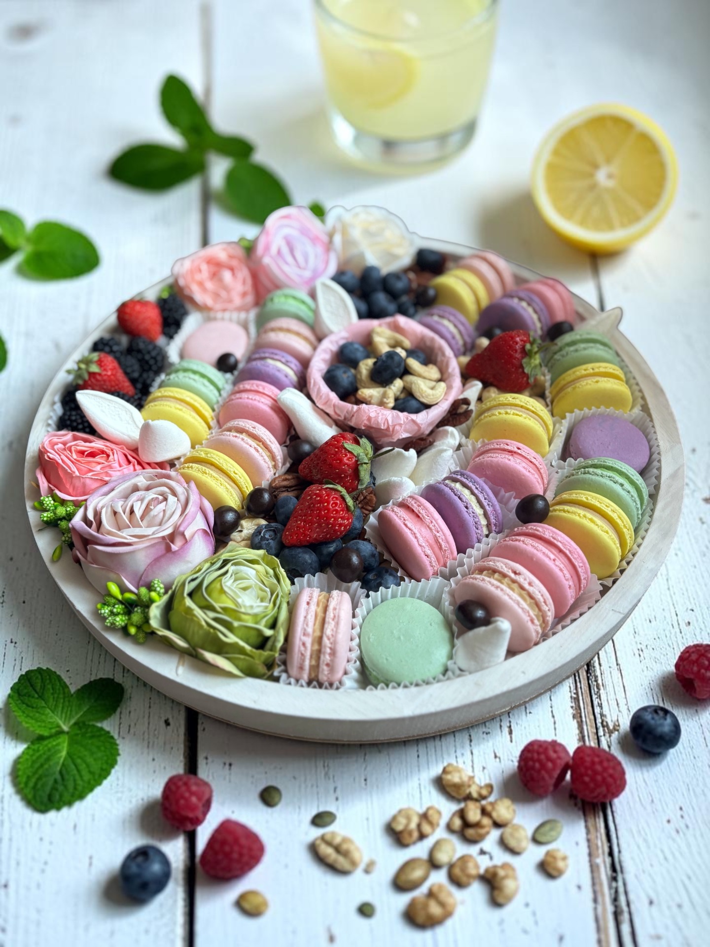Gyümölcsökkel és selyemvirágokkal gazdagon díszített ünnepi macaron kínálótál.