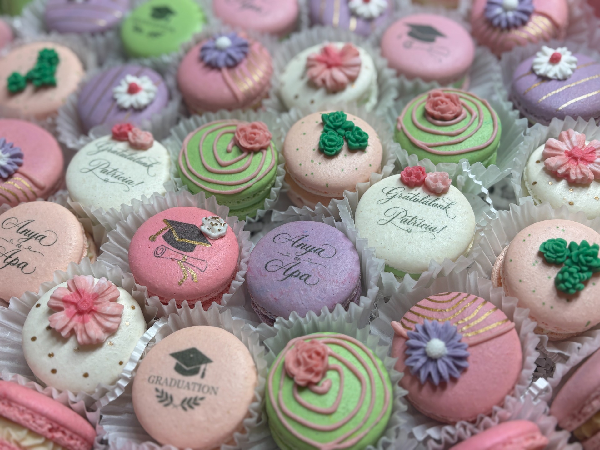 Egyedi grafikával nyomtatott és kézműves díszítésű macaron válogatás diplomaosztóra.